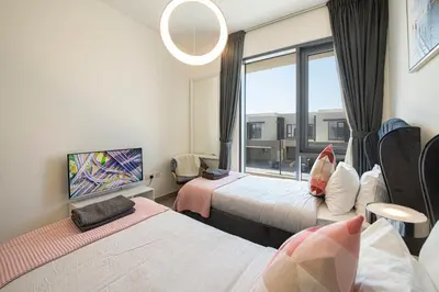 a hotel room with two beds and a window at Modern Dubai Hills Luxury 4 BEDROOM VILLA in Dubai
