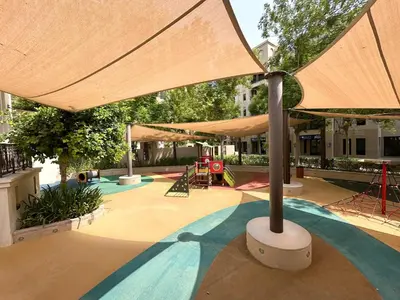 a large umbrella over a pool with a playground at Trophy 2BR Aladdin Estate w Burj Khalifa View in Dubai