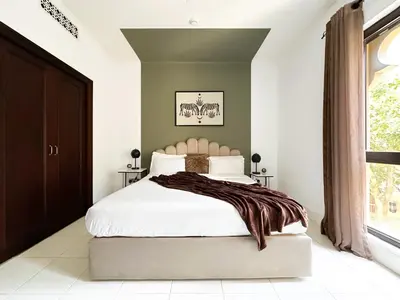 a bedroom with a white bed with a blanket on it at Trophy 2BR Aladdin Estate w Burj Khalifa View in Dubai