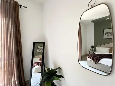 a bedroom with a mirror and a bed at Trophy 2BR Aladdin Estate w Burj Khalifa View in Dubai