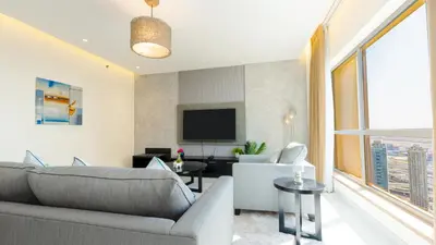 a living room with a couch and a tv at Regent Sea View 2BR Apartment JBR Beach Walk - next to Bluewater Island & Dubai Eye in Dubai