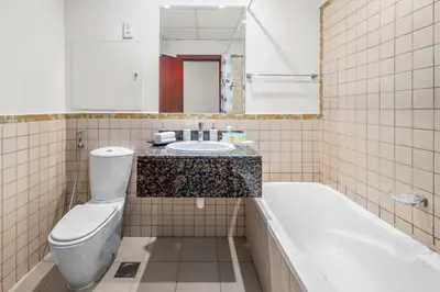 a bathroom with a toilet and a sink and a tub at Lovely 2-bed condo in JBR - 5 mins from beach - Palm View! in Dubai