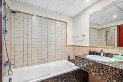 a bathroom with a tub and a sink at Lovely 2-bed condo in JBR - 5 mins from beach - Palm View! in Dubai