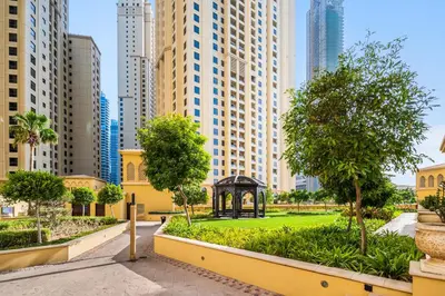 a park in the middle of a city with tall buildings at Lovely 2-bed condo in JBR - 5 mins from beach - Palm View! in Dubai