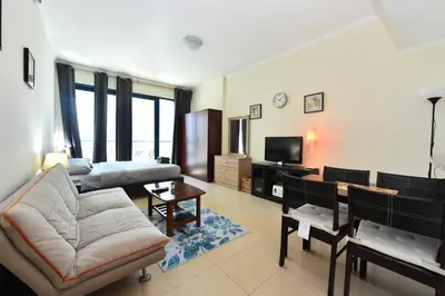 a living room with a couch and a dining room at Luxury Escapes - Studio in JLT X1 Tower close to Metro in Dubai