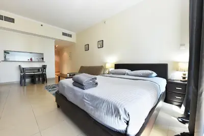 a bedroom with a bed and a table and a chair at Luxury Escapes - Studio in JLT X1 Tower close to Metro in Dubai
