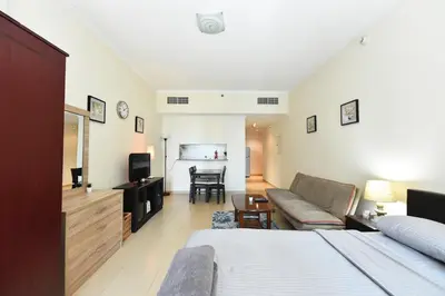 a bedroom with a bed and a couch and a television at Luxury Escapes - Studio in JLT X1 Tower close to Metro in Dubai