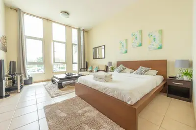 a bedroom with a large bed and a living room at Luxury Escapes - Budget Studio Apt near Metro Stn - MOG184 DG in Dubai