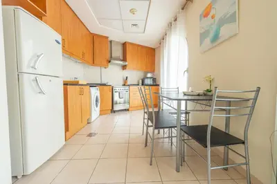 a kitchen with a table and chairs and a refrigerator at Luxury Escapes - Budget Studio Apt near Metro Stn - MOG184 DG in Dubai