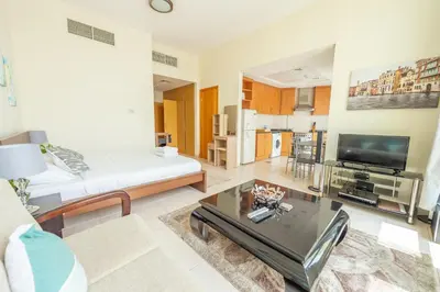 a living room with a couch and a tv at Luxury Escapes - Budget Studio Apt near Metro Stn - MOG184 DG in Dubai