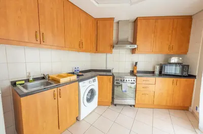 a kitchen with a sink and a washing machine at Luxury Escapes - Budget Studio Apt near Metro Stn - MOG184 DG in Dubai