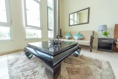 a living room with a glass table and a couch at Luxury Escapes - Budget Studio Apt near Metro Stn - MOG184 DG in Dubai