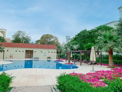 a swimming pool with a pavilion and palm trees and flowers at Luxury Escapes - Cozy budget studio near Metro & Ibn Battuta Mall - MOG190 DG in Dubai