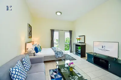 a living room with a couch and a tv at Luxury Escapes - Cozy budget studio near Metro & Ibn Battuta Mall - MOG190 DG in Dubai