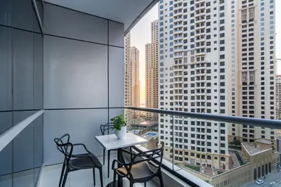a balcony with a table and chairs and a view of buildings at GuestReady - Elegant 1BR w/ Balcony | Dubai Marina in Dubai