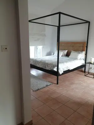 a black canopy bed in a bedroom with a tile floor at Cherrywood House in Dubai