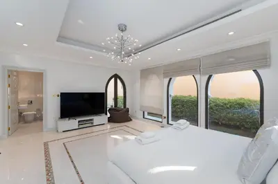 a bedroom with a white bed and a tv at Palm Jumeirah - Property Advisers in Dubai