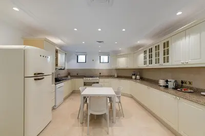 a kitchen with a table and a white refrigerator at Palm Jumeirah - Property Advisers in Dubai