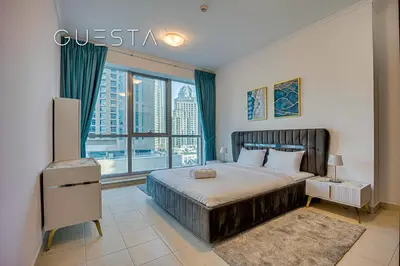a bedroom with a large bed and a large window at The Torch, Dubai Marina in Dubai