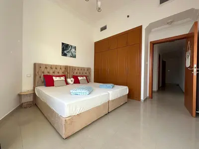 a bedroom with a large white bed with red pillows at 2 BR apartment with a beautiful view of the Marina minimum 5 night in Dubai