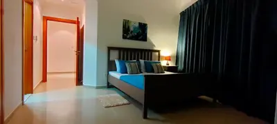 a bedroom with a bed with blue pillows at 2 BR apartment with a beautiful view of the Marina minimum 5 night in Dubai