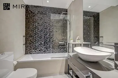 a bathroom with two sinks and a tub and a sink at Mira Holiday Homes - Lovely Studio in AG tower with free parking in Dubai