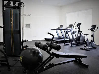 a gym with several rows of exercise bikes and weights at Mira Holiday Homes - Lovely Studio in AG tower with free parking in Dubai
