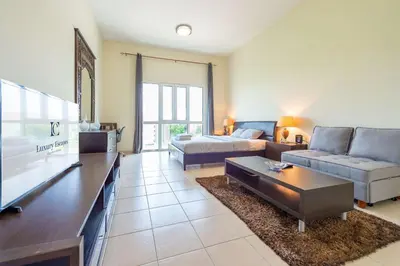 a living room with a couch and a tv at Luxury Escapes - Stylish Studio in DG near to Mall & Metro - KSLV in Dubai