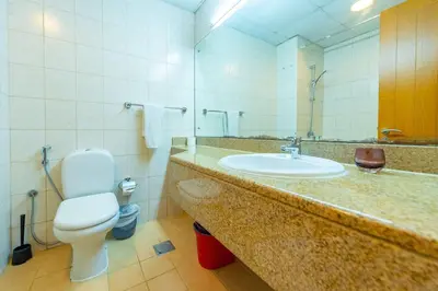 a bathroom with a sink and a toilet and a mirror at Luxury Escapes - Stylish Studio in DG near to Mall & Metro - KSLV in Dubai