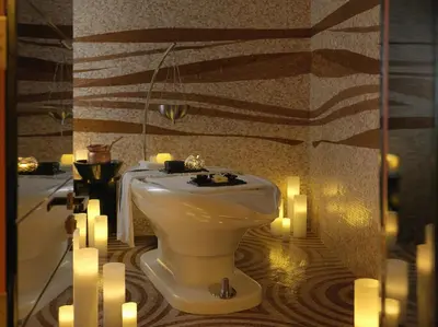 a bathroom with a white toilet in a room with candles at DAMAC Maison Mall Street in Dubai