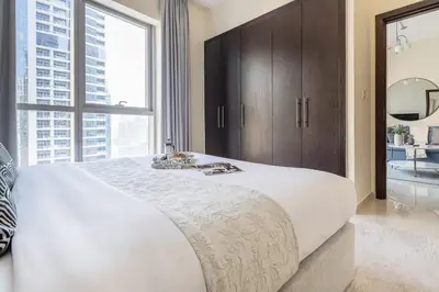 a large white bed in a bedroom with a large window at Frank Porter - Bay Central in Dubai