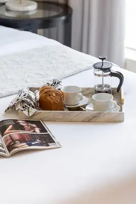 a tray with coffee cups and a pastry on a table at Frank Porter - Bay Central in Dubai