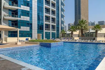 a large swimming pool in front of a tall building at Frank Porter - Bay Central in Dubai