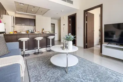 a living room with a table and a kitchen at Frank Porter - Bay Central in Dubai