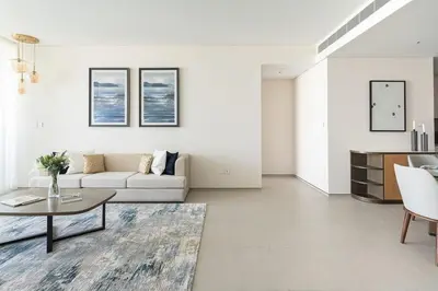 a white living room with a couch and a table at Frank Porter - The Address JBR in Dubai