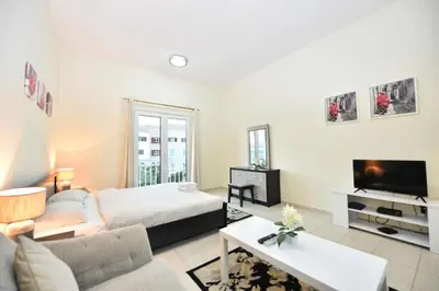 a living room with a bed and a tv at Luxury Escapes - Budget Studio with Garden Views near Metro - MED64 DG in Dubai