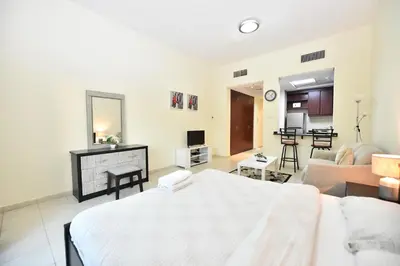 a living room with a bed and a couch at Luxury Escapes - Budget Studio with Garden Views near Metro - MED64 DG in Dubai