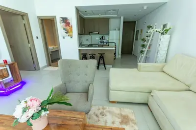 a living room with a couch and a chair at Deluxe One Bedroom Apartment for rent in Dubai Al Barsha south in Dubai