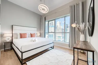 a bedroom with a large bed and a large window at Elegant 2BR at The Point Dubai Marina by Deluxe Holiday Homes in Dubai
