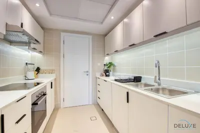a kitchen with white cabinets and a sink at Elegant 2BR at The Point Dubai Marina by Deluxe Holiday Homes in Dubai