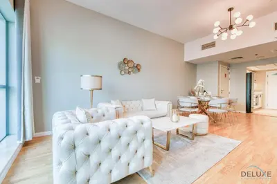 a living room with a white couch and a table at Elegant 2BR at The Point Dubai Marina by Deluxe Holiday Homes in Dubai