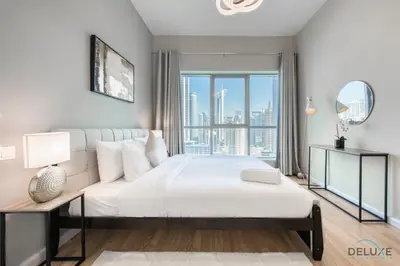 a bedroom with a large white bed and a large window at Elegant 2BR at The Point Dubai Marina by Deluxe Holiday Homes in Dubai
