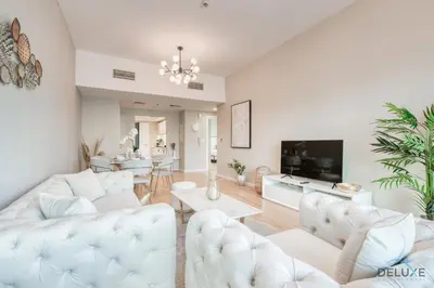 a living room with white furniture and a dining room at Elegant 2BR at The Point Dubai Marina by Deluxe Holiday Homes in Dubai