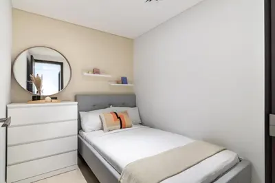 a small bedroom with a bed and a mirror at GuestReady - The Ivory Coast Downtown Views in Dubai