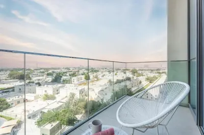a balcony with a white chair and a view of the city at GuestReady - The Ivory Coast Downtown Views in Dubai