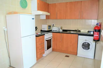 a kitchen with a white refrigerator and a dishwasher at Luxury Escapes - 1BR with Balcony & Stunning Marina View - MVT in Dubai