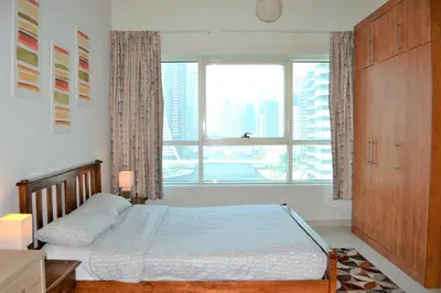 a bedroom with a bed and a large window at Luxury Escapes - 1BR with Balcony & Stunning Marina View - MVT in Dubai