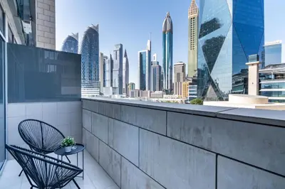 a balcony with a chair and a view of the city at Silkhaus elegant studio in the central DIFC with balcony and city views in Dubai
