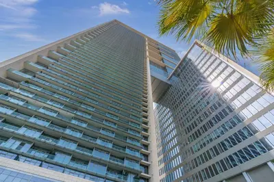 a tall building with a palm tree in front of it at Silkhaus stunning studio in central DIFC with balcony in Dubai