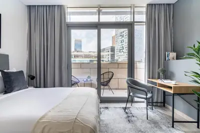 a bedroom with a bed and a desk and a window at Silkhaus stunning studio in central DIFC with balcony in Dubai